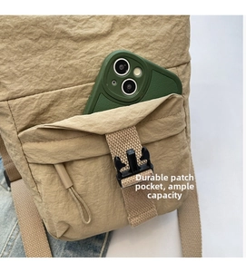 Detalle del bolso de nailon beige para móvil con bolsillo frontal y hebilla ajustable