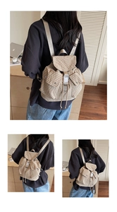 Close-up of drawstring closure and silver metal buckle on checkered canvas backpack