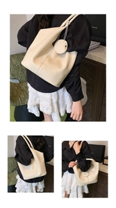Detail of cream large tote bag in pebble leather texture with stylish side pendant