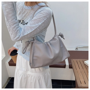 Detail der grauen Cloud Bag mit Faltenoptik, weichem Leder und dekorativem Knotengurt
