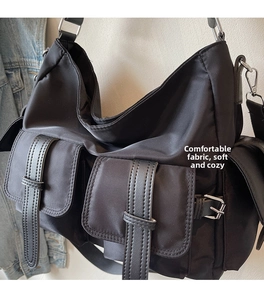 Detail of nylon crossbody bag with multi-pocket utility design and silver metal buckles