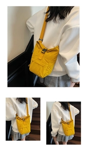 Detalle del bolso bandolera de nailon amarillo con cierre de hebilla y correa
