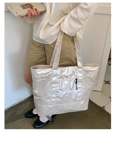 Détail du sac cabas matelassé en nylon crème avec fermeture éclair frontale et bretelles