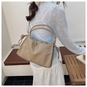 Détail du sac nuage plissé avec poignée nouée et texture chic en similicuir beige doux