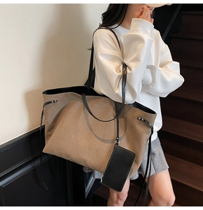 Detail of tan canvas tote bag with black leather straps and matching zip pouch bag