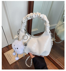 Detail of white pleated handle bag with silver chain and cute plush cloud charm