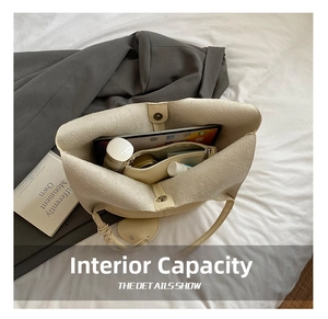Spacious interior of beige leather tote bag with magnetic clasp and small storage pouch