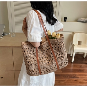 Detail of hollow floral woven tote bag with dark brown leather straps and tulip decor