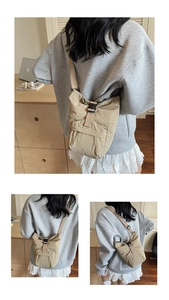 Detalle del bolso de nailon beige con cierre de hebilla y acabado de textura plisada