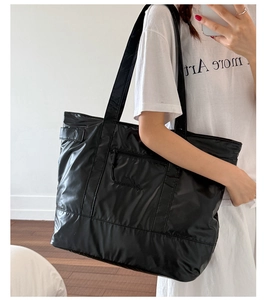 Détail du grand sac cabas en nylon noir brillant avec fermeture éclair et intérieur spacieux