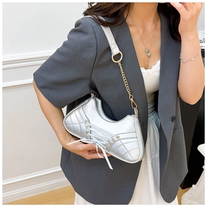 Detail of silver sneaker-shaped shoulder bag featuring lace-up design and quilted texture