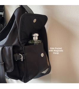 Detail of the side pocket with a metal magnetic buckle on the black tote bag
