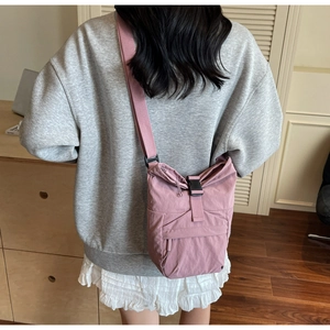Foto de modelo de bolso bandolera de nailon rosa empolvado con hebilla y correa ancha