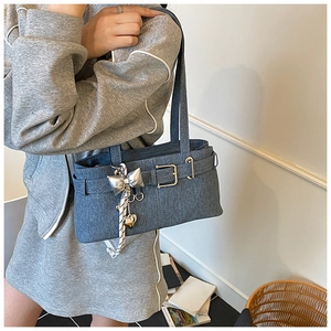 Detail of vintage blue denim tote bag featuring decorative belt buckles and heart charms