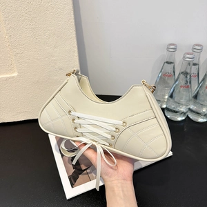 Chic cream ballet-style shoulder bag with decorative lace-up straps and quilted texture