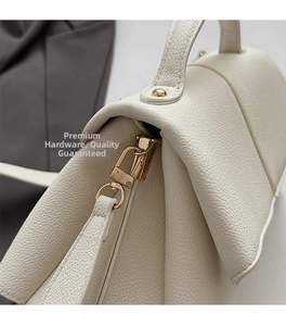 Detailed macro of cream lychee texture leather with elegant gold hardware hooks