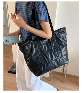 Détail du sac cabas en nylon noir imperméable avec poche zippée et broderie de marque