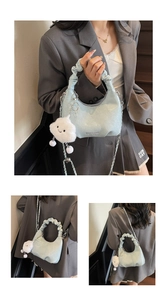 Detail of light blue pleated hobo bag with silver chain strap and cloud plush charm