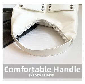 Detail view of the top zipper closure and metal rivets on this white tote bag