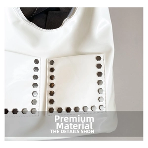 Detailed close-up of white PU leather tote bag featuring metallic hexagonal rivets