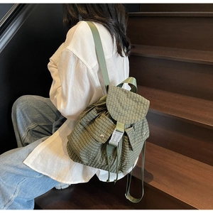 Grüner Rucksack mit Karomuster am Model für einen lässigen Outdoor-Look