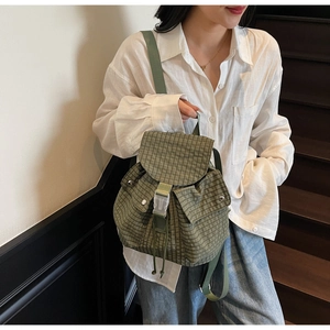 Nahaufnahme des grünen Canvas-Rucksacks mit Schachbrettmuster und Kordelzugverschluss