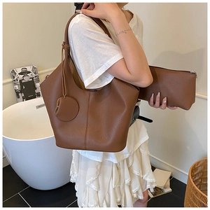 Detail of lychee pattern leather tote bag and pouch set in brown with soft texture