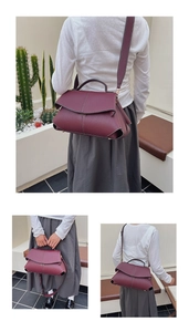 Detail of dark red lychee grain leather handbag with top handle and adjustable strap