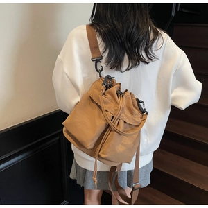 Vista posteriore di una borsa a secchiello kaki con coulisse indossata da una modella