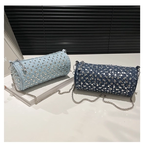 Detailed close-up of blue denim cylinder bags with silver studs and chain straps