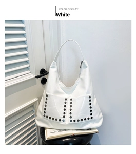 Detail shot of white hobo bag featuring glossy finish and silver hexagonal rivets
