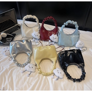 Flat lay of colorful ruched hobo bags in six colors with plush cloud charms and accessories