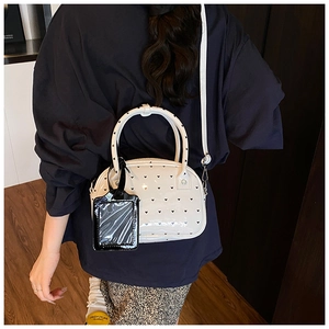 Detail of white bowling bag with heart pattern and black glossy card holder charm