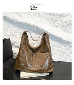 Detail view of coffee-colored tote with silver hexagonal rivets and large front pockets