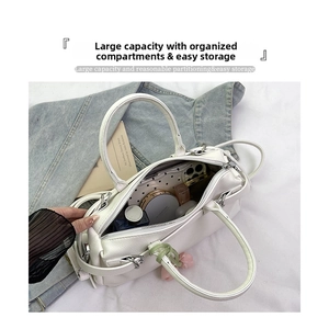 Detailed interior of a white pebbled leather handbag showing spacious storage capacity