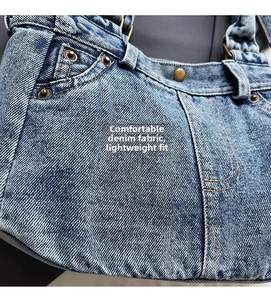 Dettaglio della borsa in denim con rivetti in bronzo vintage e texture lavata classica