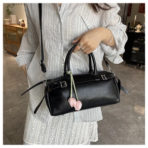 Detail of black lychee leather bag with silver hardware and pink tulip charm detail