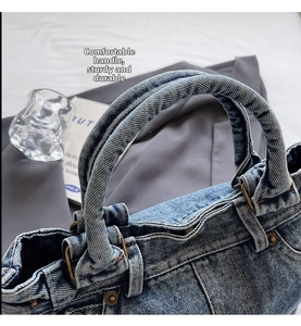 Dettaglio della borsa tote in denim blu con manici rinforzati e fibbie in rame vintage