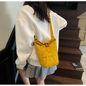 Détail de la sacoche jaune vif avec fermeture à boucle sur un mannequin en intérieur