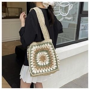 Detail of crochet tote bag with grandmother square patterns worn on the shoulder