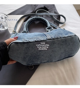 Dettaglio della borsa a mano in denim lavato blu con manici robusti e tracolla regolabile