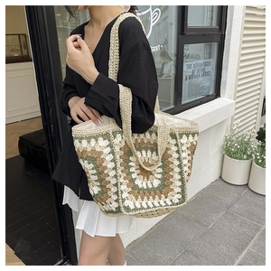 Detailed view of handmade crochet granny square tote bag with floral patterns and dual straps