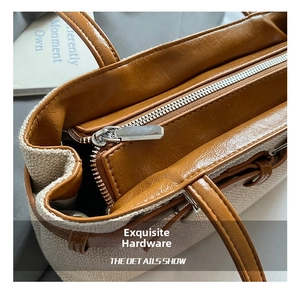 Détail de la toile tissée et du cuir marron avec fermeture éclair argentée fine