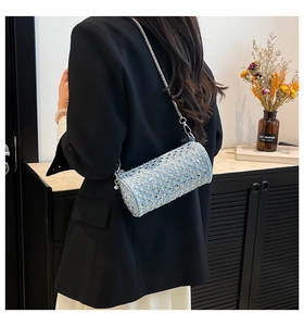 Detail of light blue denim cylinder bag with silver rhinestones and chain strap