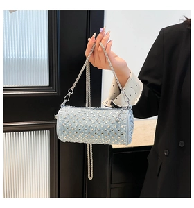 Detail of light blue denim mini round bag with silver studs and rhinestone accents