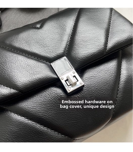 Detailed macro of black quilted leather flap bag with silver rectangular turn-lock