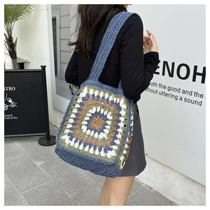 Close-up of handmade crochet tote bag with colorful granny square patterns and wide straps