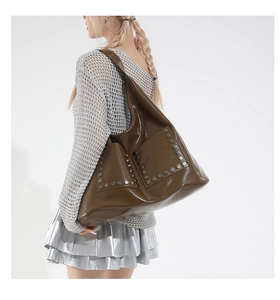 Detail shot of olive brown tote bag with silver hexagonal studs and glossy finish