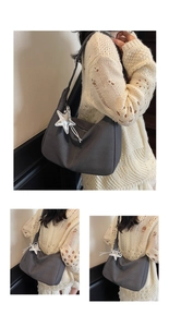 Detail der dunkelgrauen Hobo-Tasche aus Textilgewebe mit einem Sternanhänger aus Metall