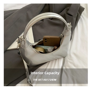 Detail showing the spacious interior of a silver patent hobo bag with essentials